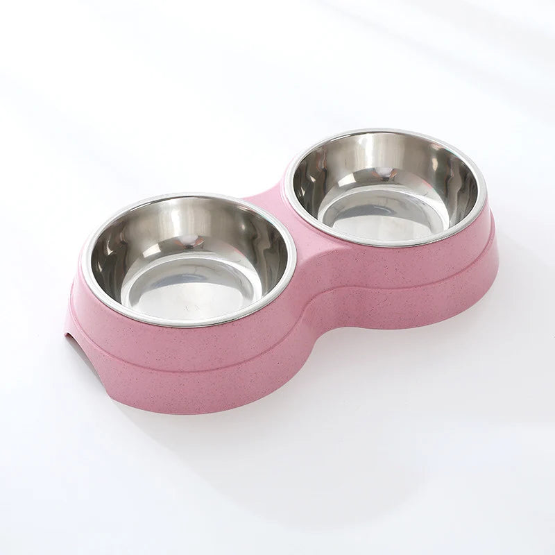 Double stainless steel pet bowl set in a pink plastic base, white background

