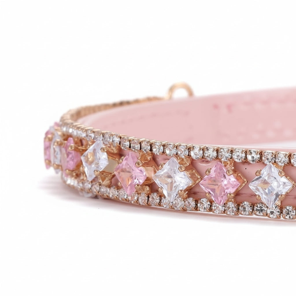 Pretty Posh Pets luxury rhinestone pet collar — close-up detail of a pink leather collar featuring alternating princess-cut pink and clear crystal gemstones set in rose gold, bordered by rows of sparkling round rhinestones on a white background.