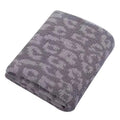 A folded gray plush blanket with a lighter gray leopard or cheetah spot pattern, shown on a solid white background.