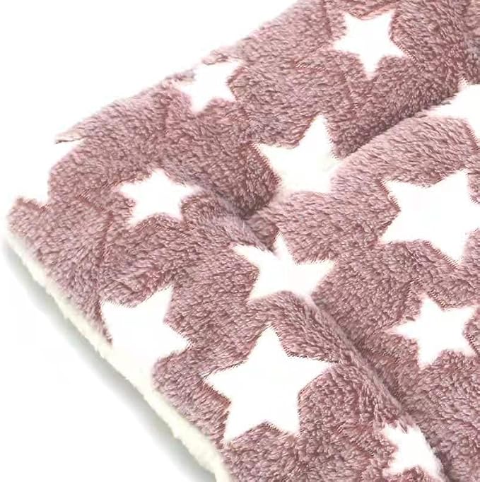 Close-up texture detail of dusty pink plush pet mat with white star print pattern showing soft sherpa lining on white background