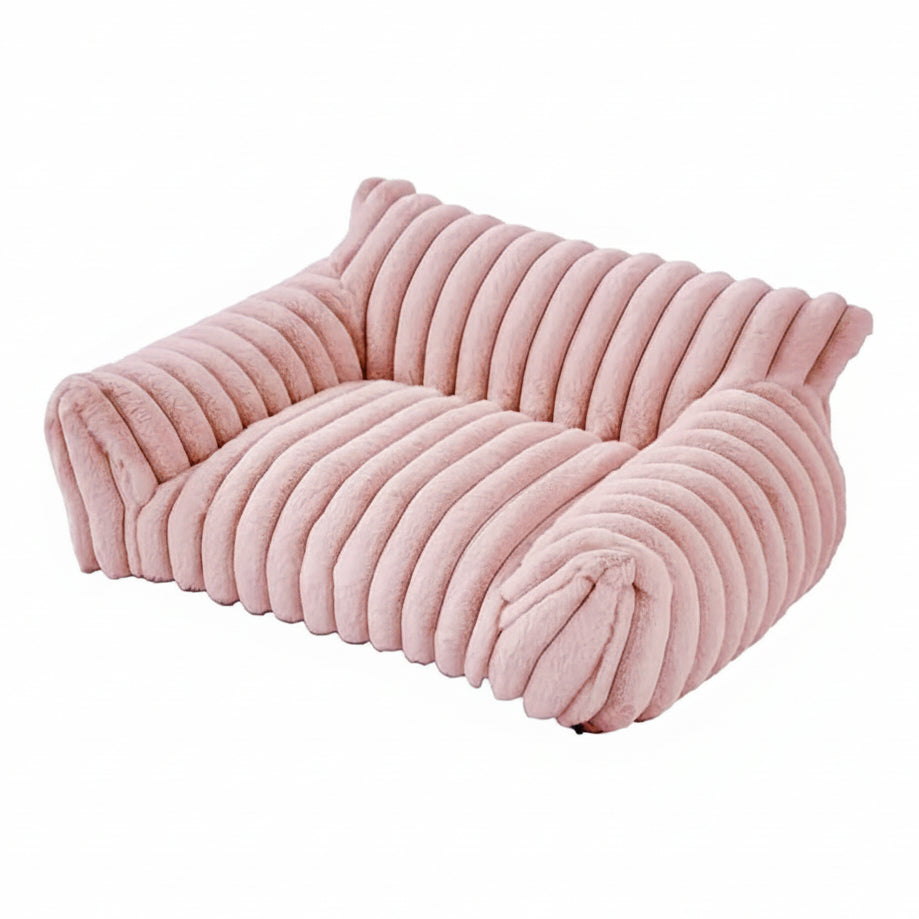 Blush pink rectangular pet sofa bed with thick ribbed channel-tufted plush fabric, raised back and side bolsters, and a flat cushioned seat, shown on a white background