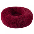 A plush, donut-shaped pet bed in a deep burgundy or dark red faux fur material, shown against a plain white background.
