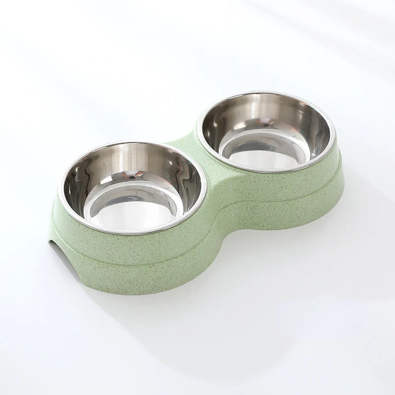 Double stainless steel pet bowl set in a green plastic base, white background
