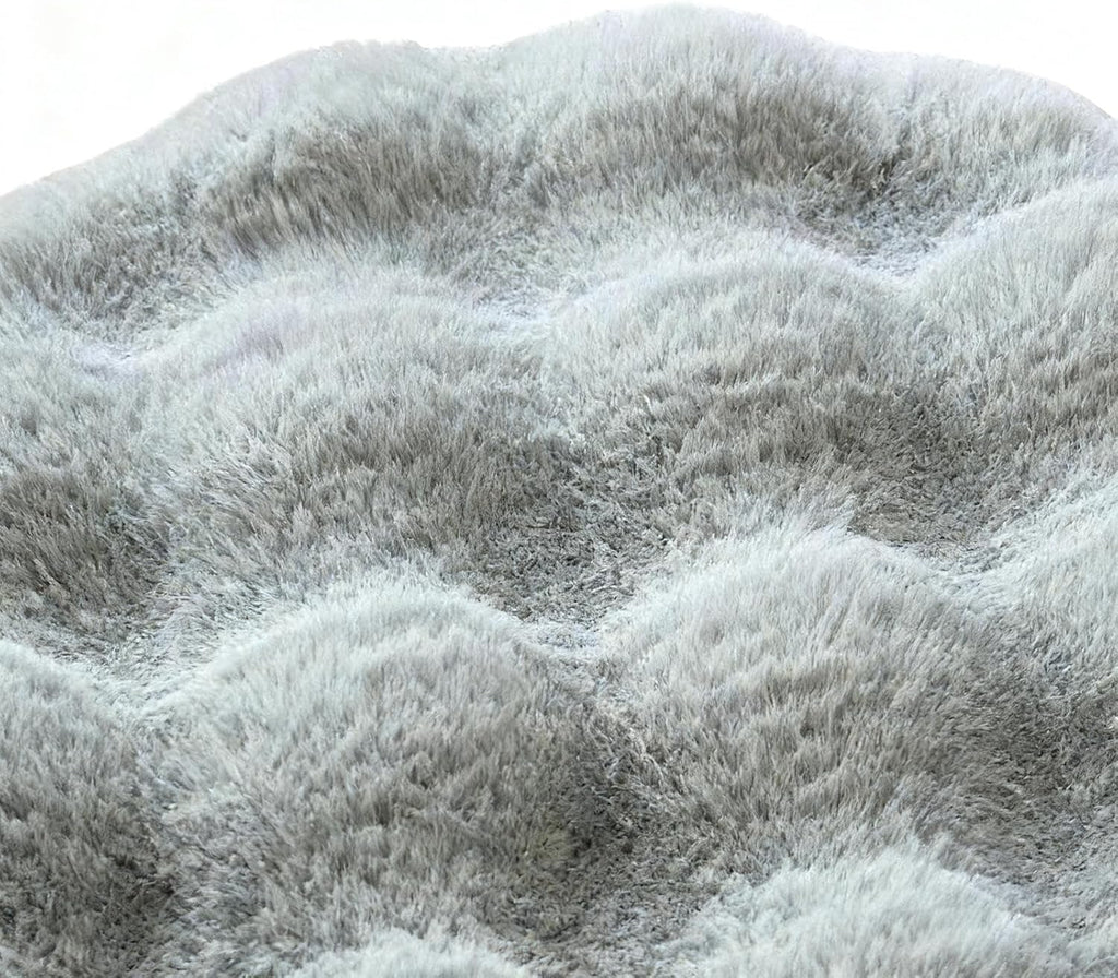 Close-up texture detail of round grey waffle-textured plush pet mat showing deep soft shaggy pile and cushioned wave pattern on white background