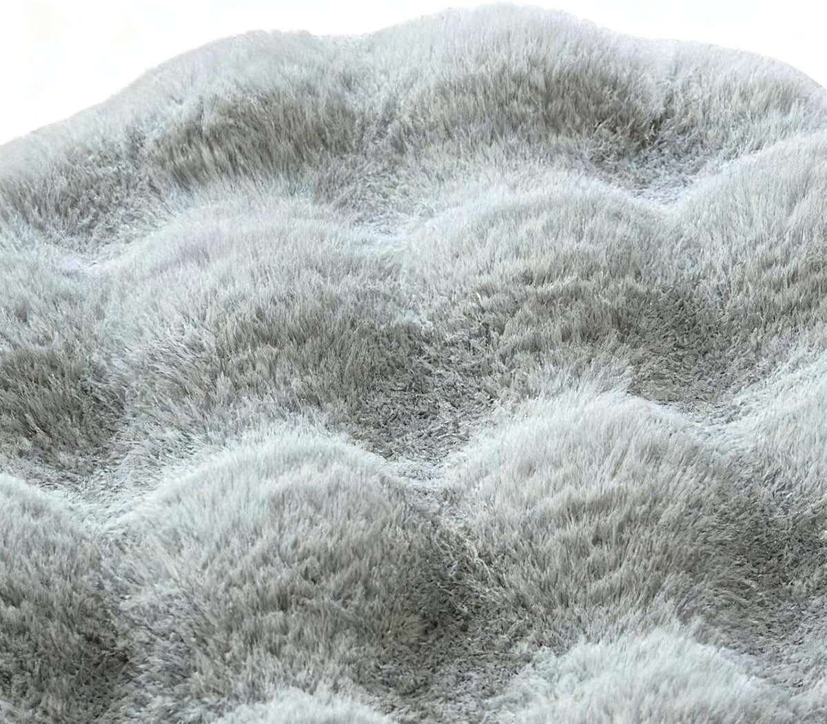 Close-up texture detail of round grey waffle-textured plush pet mat showing deep soft shaggy pile and cushioned wave pattern on white background