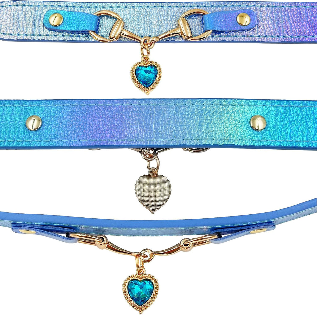 Three iridescent blue holographic pet collars with gold snaffle-bit hardware and teal blue crystal heart charm pendants, shown in a close-up detail flat lay on a white background