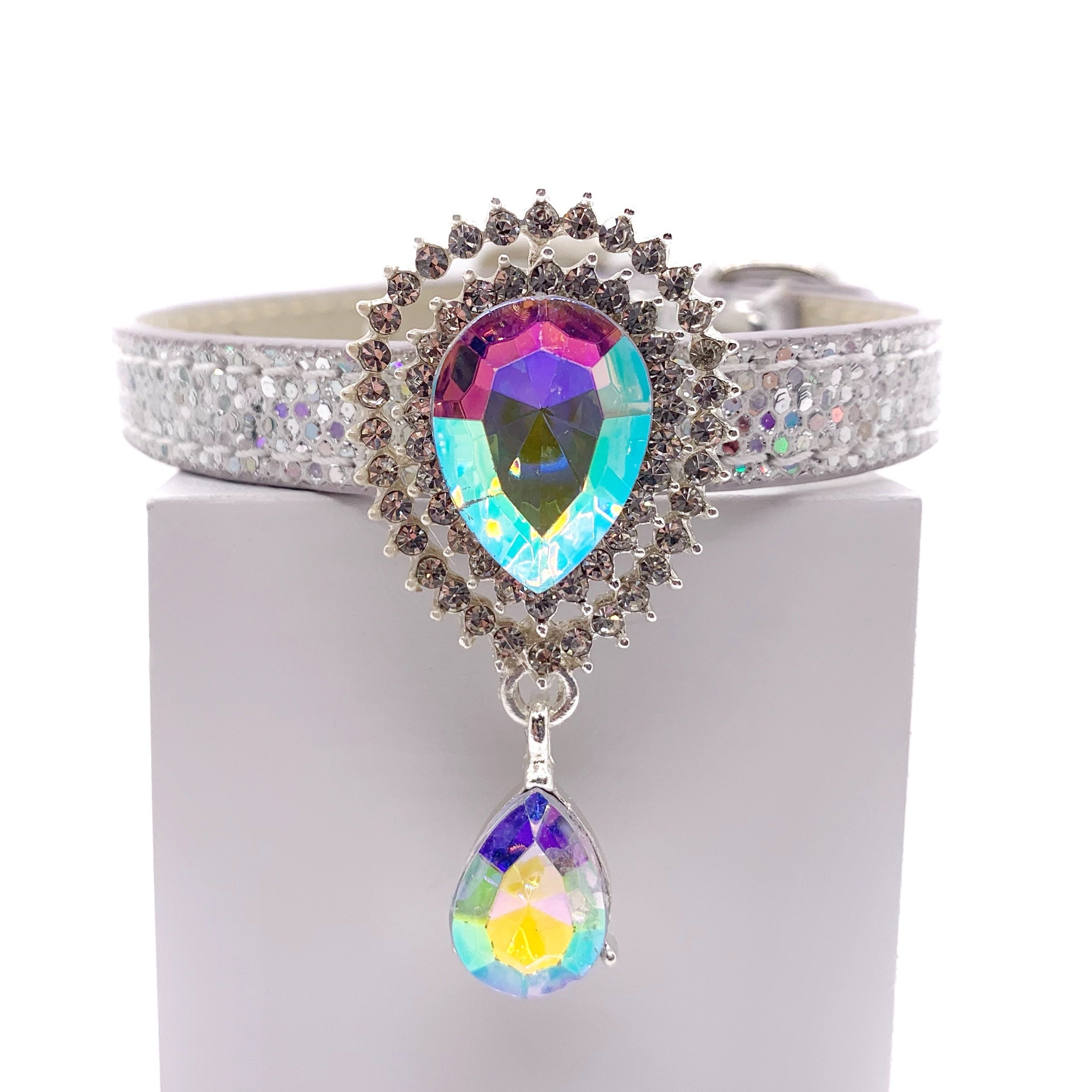 Silver glitter dog collar with large aurora borealis teardrop crystal sunburst centerpiece and dangling AB crystal drop on white stand