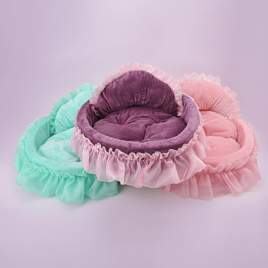 Three round-shaped ruffle pet beds in deep purple, mint teal, and blush pink with layered chiffon ruffle trim shown overlapping, lavender background