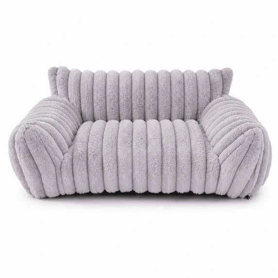 Lavender grey rectangular pet sofa bed with thick ribbed channel-tufted plush fabric, rounded raised back and armrests, and a deep cushioned seat, shown from the front on a white background