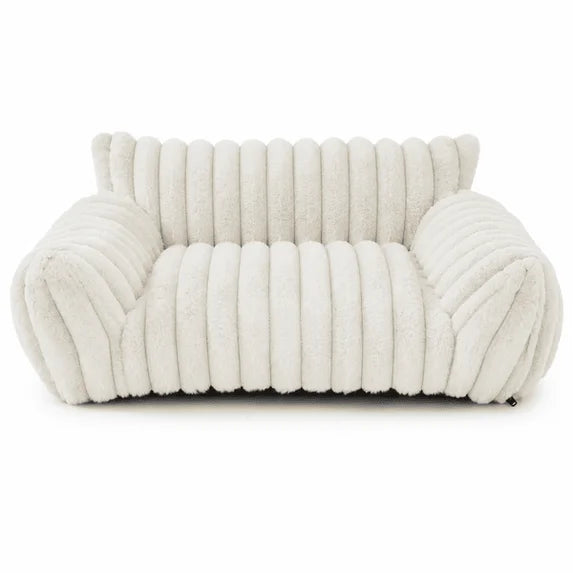 Ivory white rectangular pet sofa bed with thick ribbed channel-tufted plush fabric, rounded raised back and armrests, and a deep cushioned seat, shown from the front on a white background