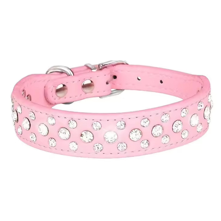 A pink faux leather dog collar embellished with clear rhinestones, featuring a silver-tone buckle and D-ring, shown against a plain white background.