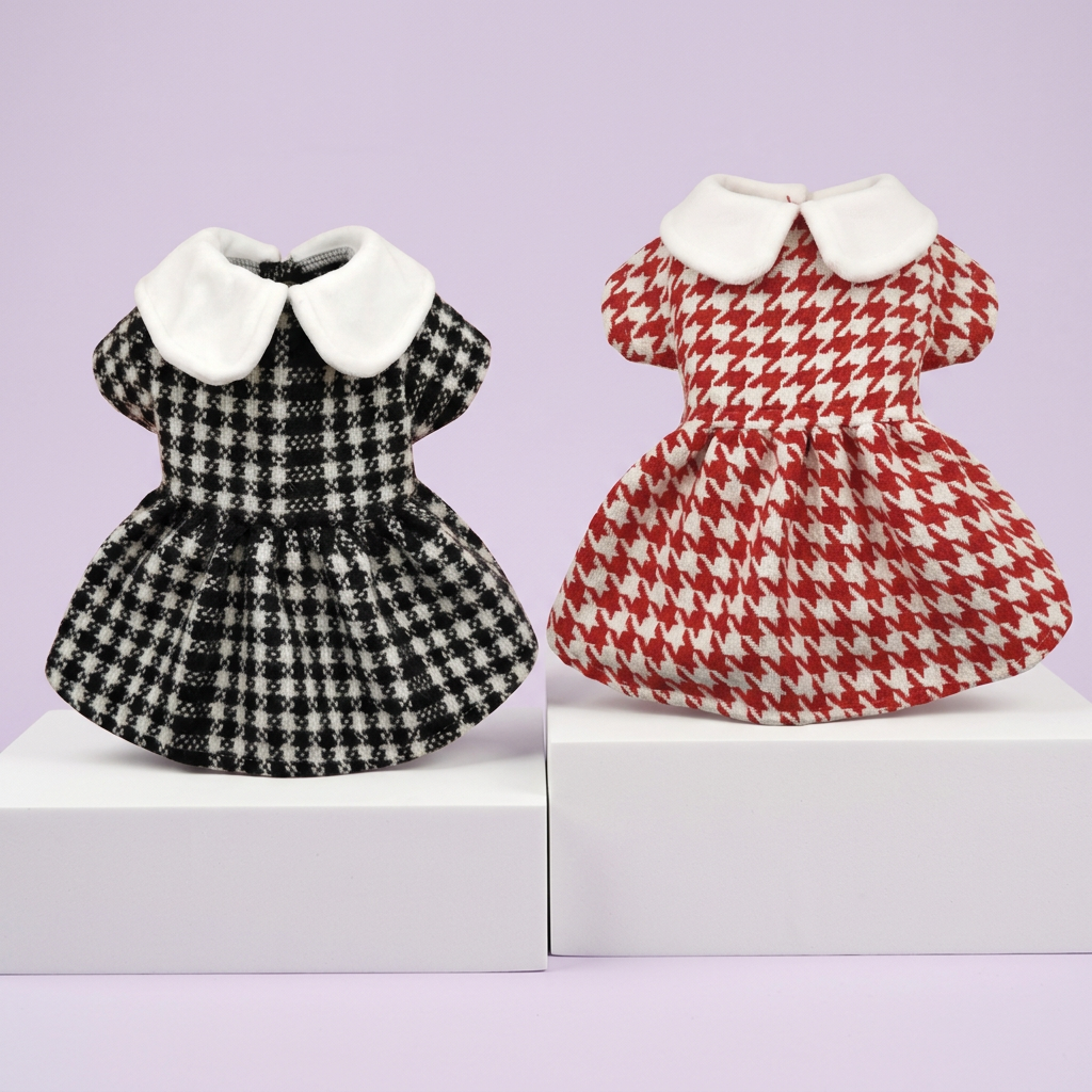 Black-and-white and red-and-ivory houndstooth pet dresses on white display tiers against soft lavender