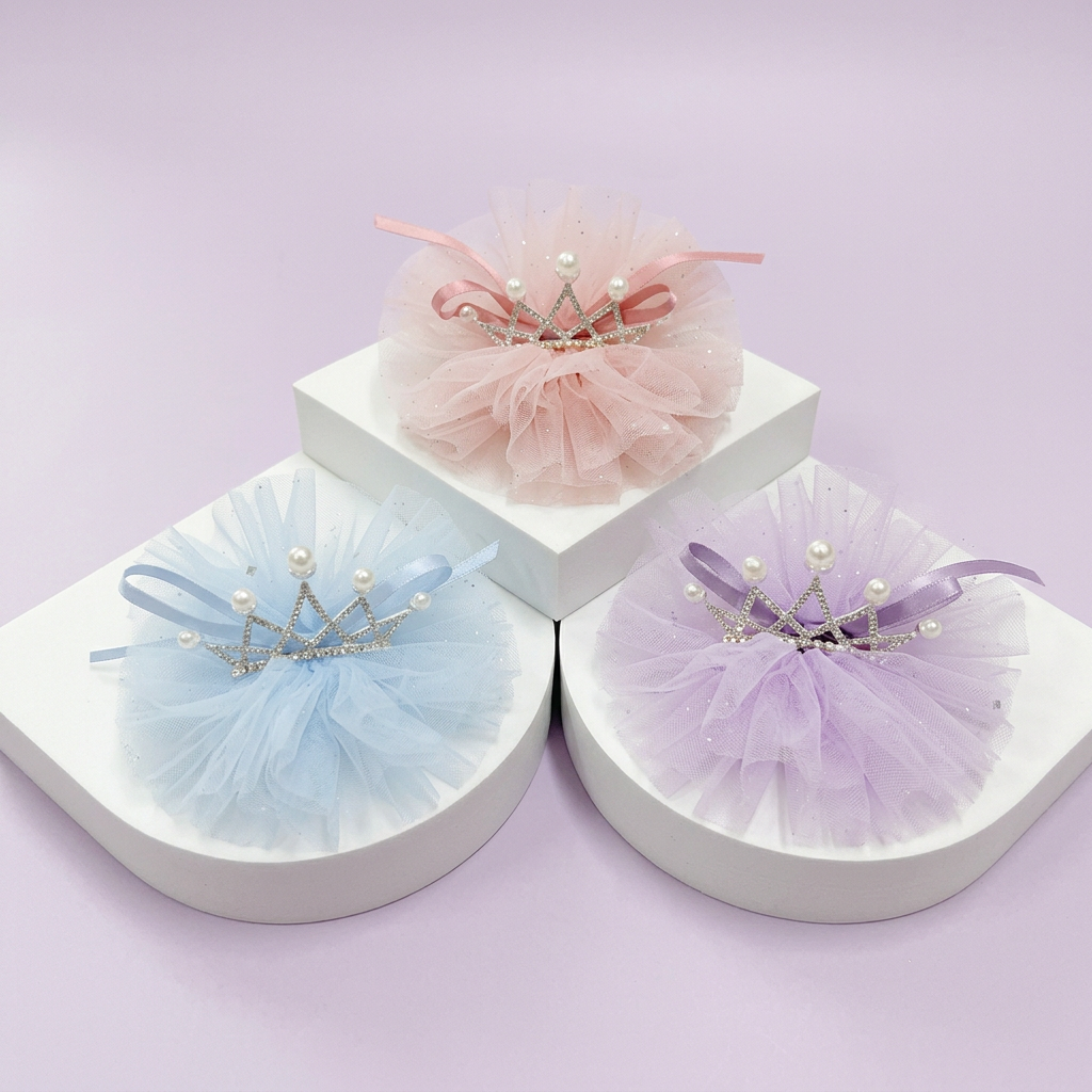 Blue, pink, and lavender crown tulle hair clips on a white tiered display against light lavender
