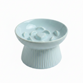 Mint blue ceramic raised slow feeder cat bowl with ribbed pedestal base and heart-center ridge pattern, white background