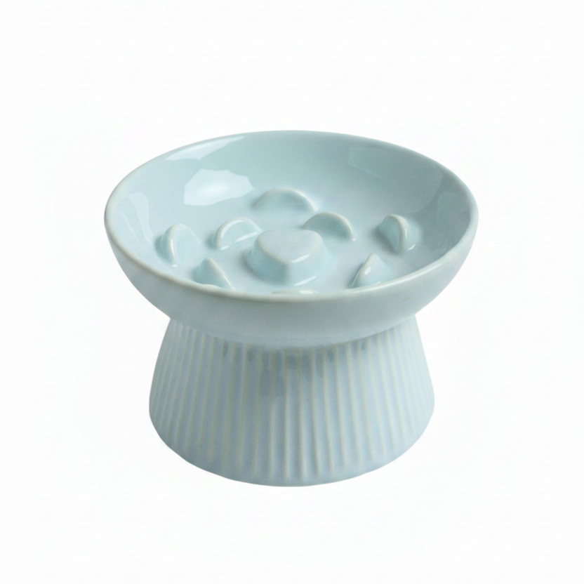 Mint blue ceramic raised slow feeder cat bowl with ribbed pedestal base and heart-center ridge pattern, white background
