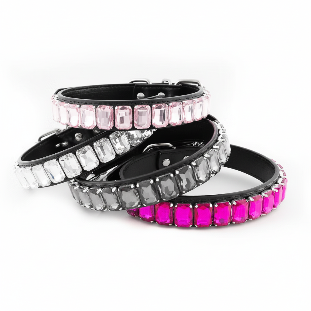 Stack of black rhinestone pet collars featuring clear, pale pink, charcoal grey, and bright fuchsia rectangular crystals on a white background.