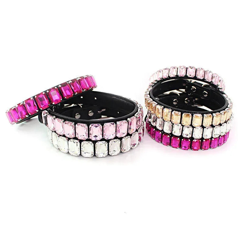 Four black rhinestone pet collars arranged in two stacks, featuring hot-pink, pale pink, clear, cream, and white rectangular crystals on a white background.