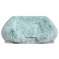 Mint green long shaggy faux fur rectangular pet sofa bed with raised bolster sides and a flat cushioned center, shown from the front on a white background