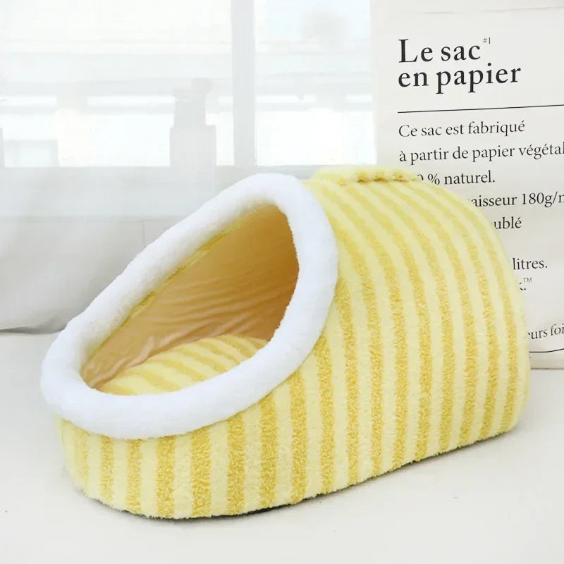 Butter yellow corduroy cave pet bed with a white fleece-lined oval opening, photographed from the side in a bright minimal setting.