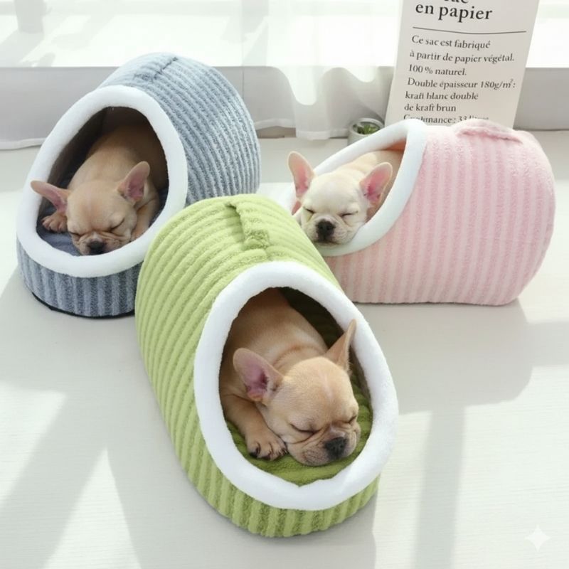 Three French Bulldogs sleeping inside oval corduroy cave pet beds in sage green, grey, and pink colorways, displayed together on a white surface.
