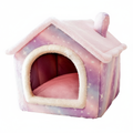 Pink and purple galaxy star print house-shaped pet bed with fluffy pink sherpa roof, cream arched entrance trim, chimney detail, and pink cushioned interior on a clean white background