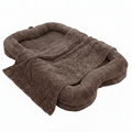 Oversized chocolate brown plush human-sized dog bed with bone-shaped bolster sides and matching faux fur blanket on white background