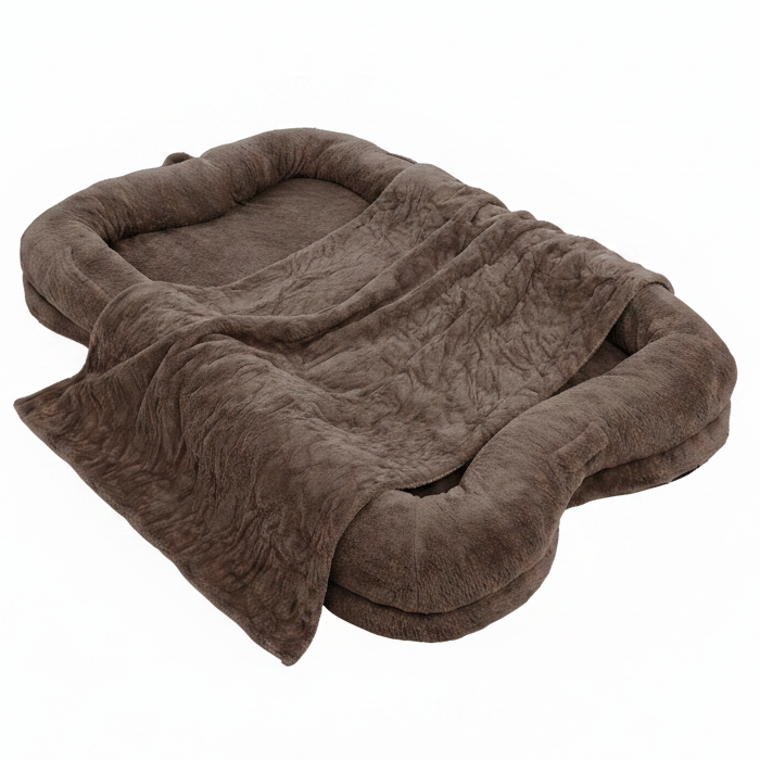 Oversized chocolate brown plush human-sized dog bed with bone-shaped bolster sides and matching faux fur blanket on white background