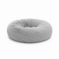 Light grey round donut pet bed with long shaggy faux fur and a deep cushioned center, shown on a white background