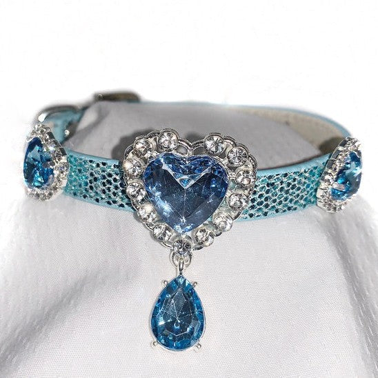 Blue decorative dog collar with heart-shaped and teardrop-shaped gemstones on a white background
