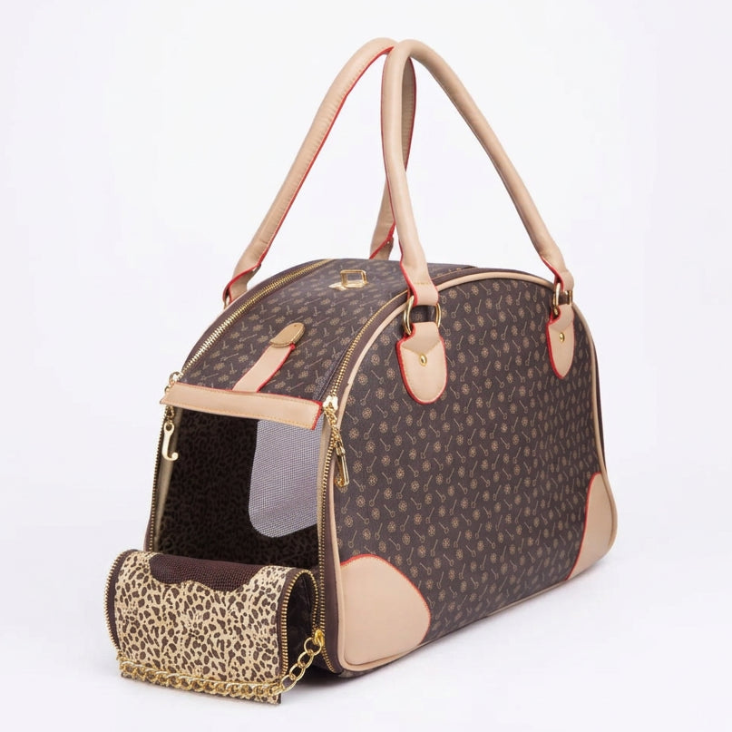 A brown patterned pet carrier bag with beige handles and trim, shown open with a matching leopard-print pouch attached by a gold chain, on a white background.