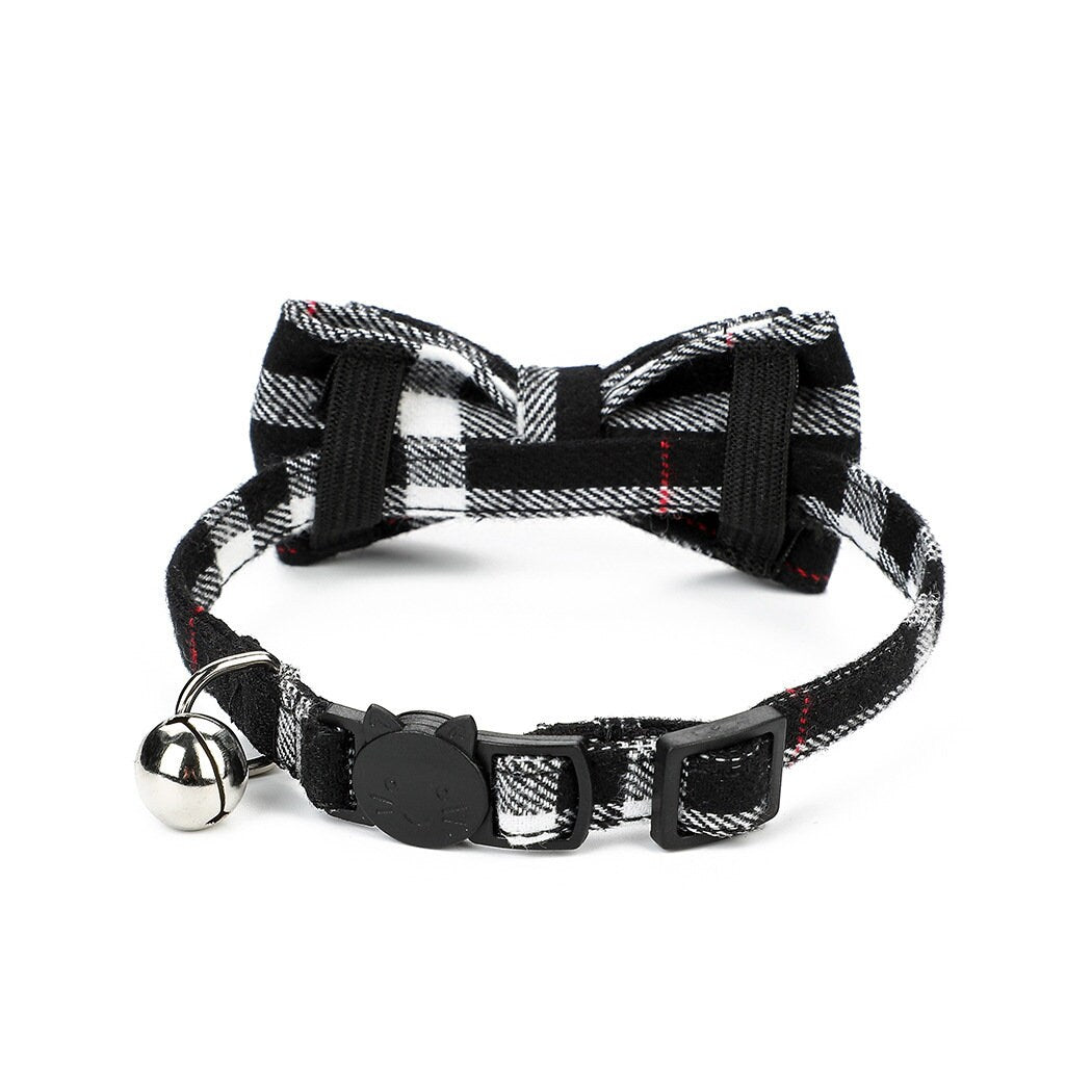 Black and white tartan plaid cat collar with bow tie, silver bell, and cat-shaped safety breakaway buckle with red accent stripe