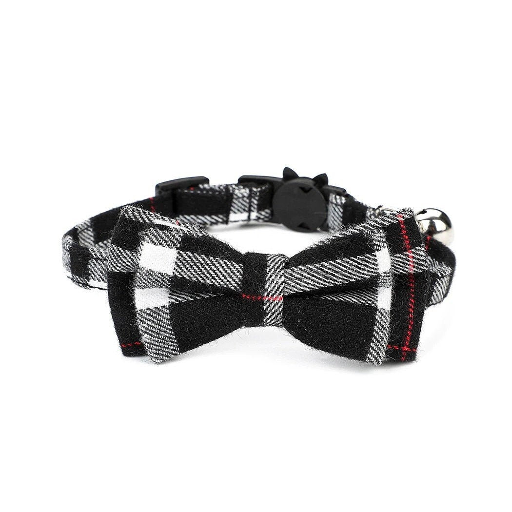 Black and white plaid bow tie cat collar with a bell on a white background