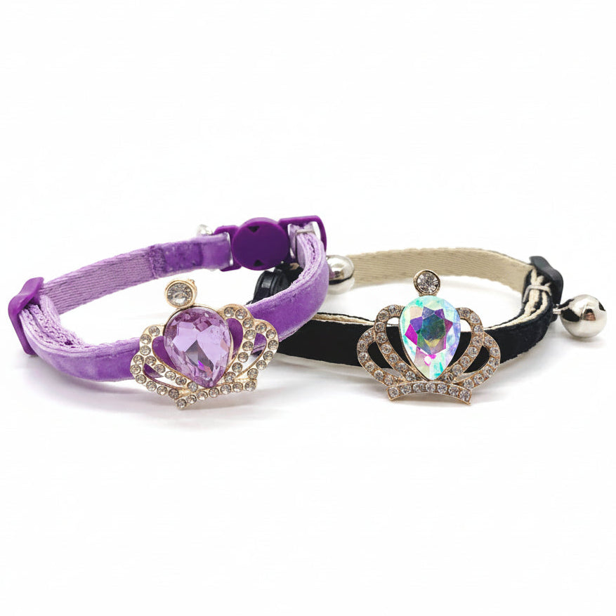 Luxury pet collar collection featuring purple velvet with amethyst crown rhinestone charm and black velvet with aurora borealis iridescent crown crystal charm, both with silver bells for cats and dogs