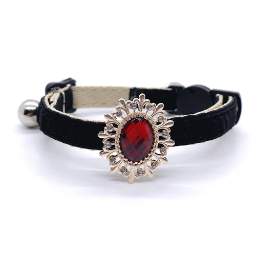 Black velvet pet collar with a decorative gold and red gemstone on a white background for cats and dogs