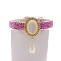 Pink glitter luxury pet collar with gold oval moonstone centerpiece, crystal halo, and dangling pearl teardrop charm