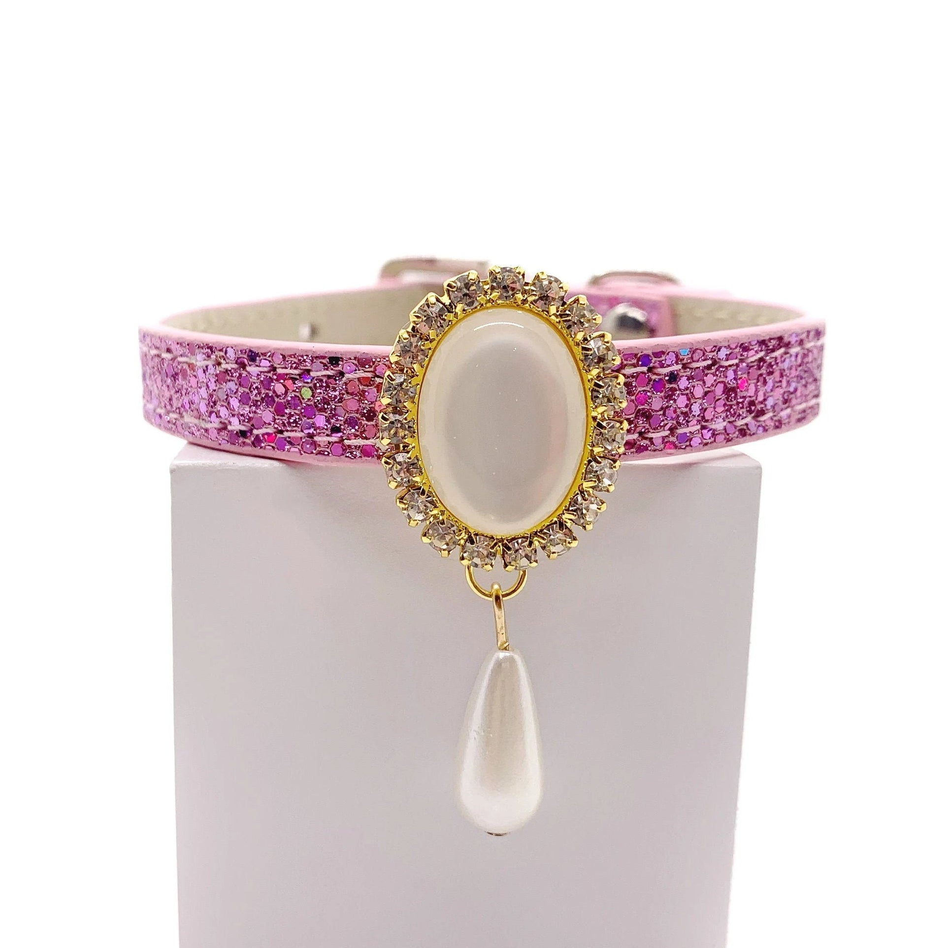 Pink glitter luxury pet collar with gold oval moonstone centerpiece, crystal halo, and dangling pearl teardrop charm