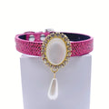 Hot pink snakeskin luxury pet collar with gold oval moonstone centerpiece, crystal halo, and dangling pearl teardrop charm