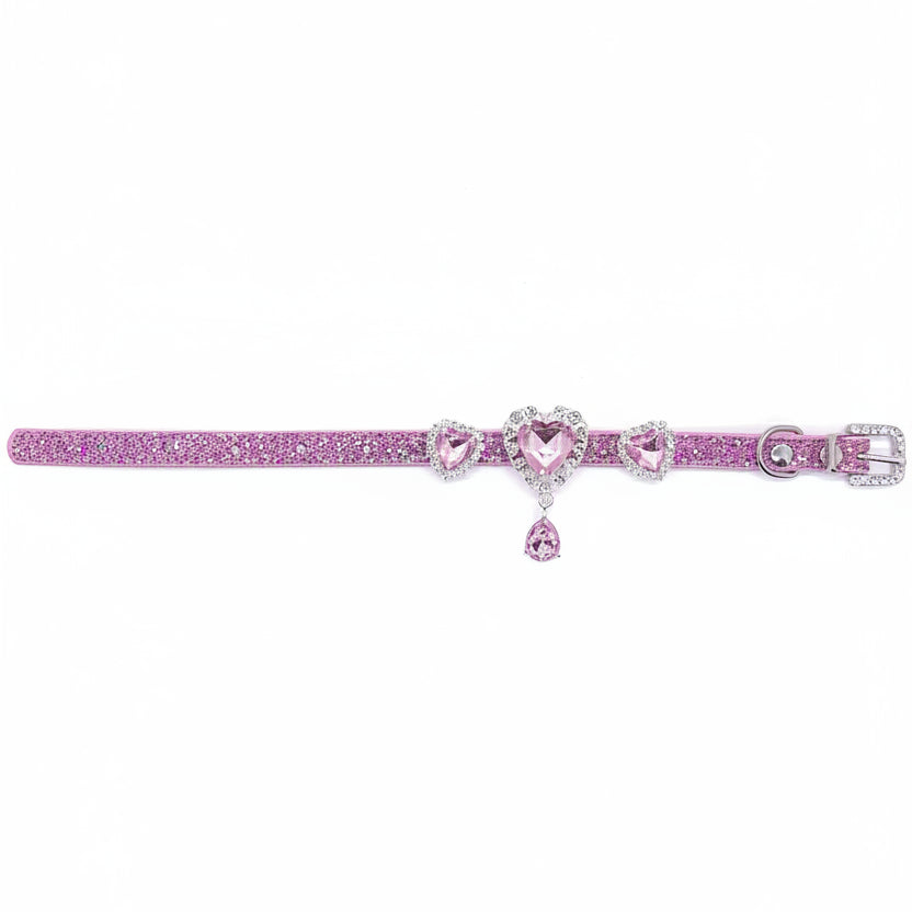 Pink glitter pet collar with three rose pink heart crystal charms in rhinestone halo settings, center charm with dangling pink teardrop crystal drop, laid flat showing full length with rhinestone-encrusted buckle for cats and dogs