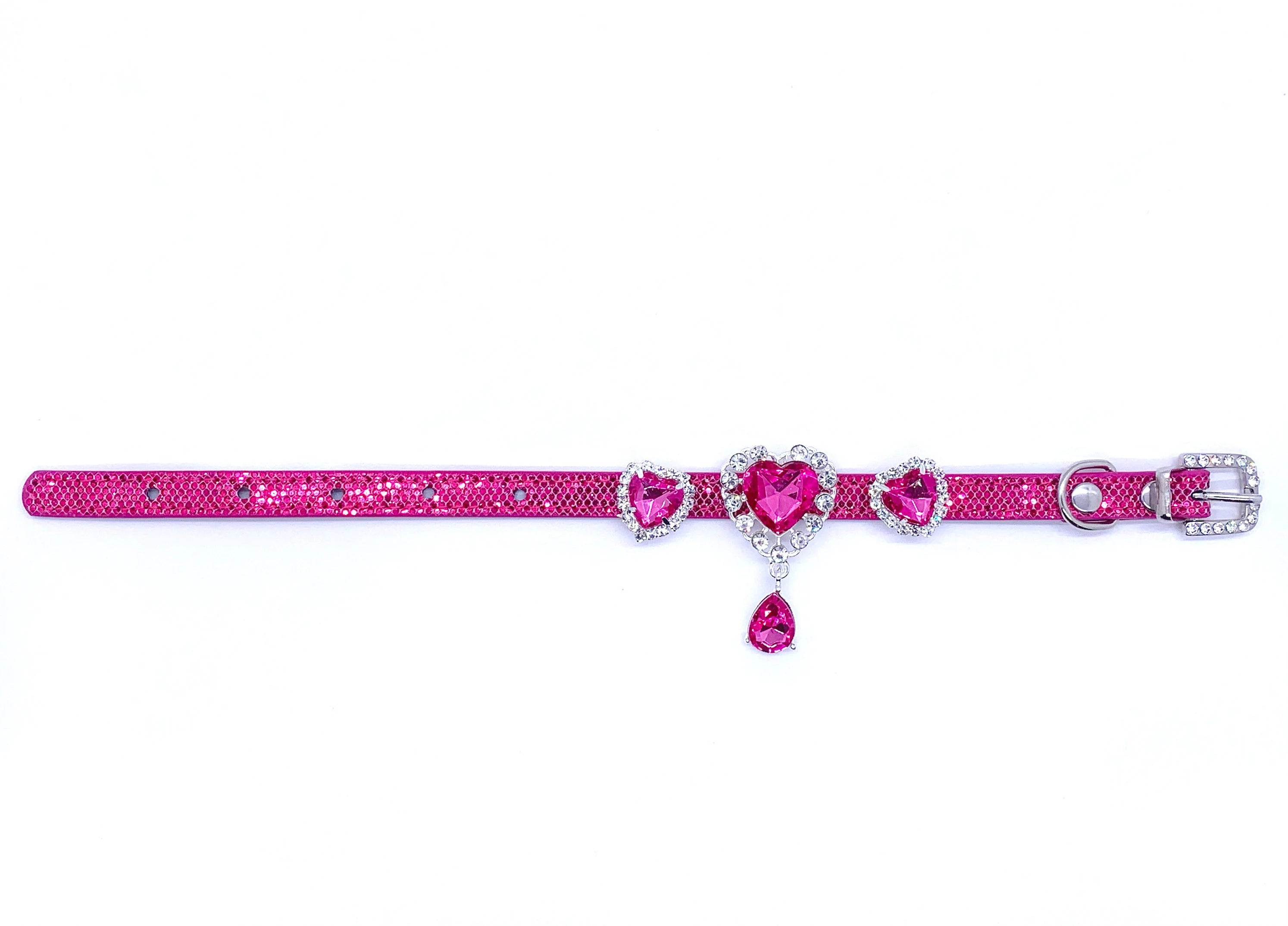 Pink glittery pet collar with heart-shaped embellishments on a white background for cats and dogs
