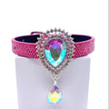 Hot pink metallic honeycomb texture pet collar with aurora borealis iridescent teardrop brooch, double rhinestone halo, and dangling AB crystal teardrop charm displayed on stand for cats and dogs