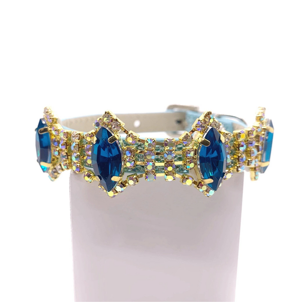 Blue iridescent glitter pet collar with full-band sapphire blue marquise crystals and aurora borealis AB rhinestone accents in gold settings displayed on stand for cats and dogs