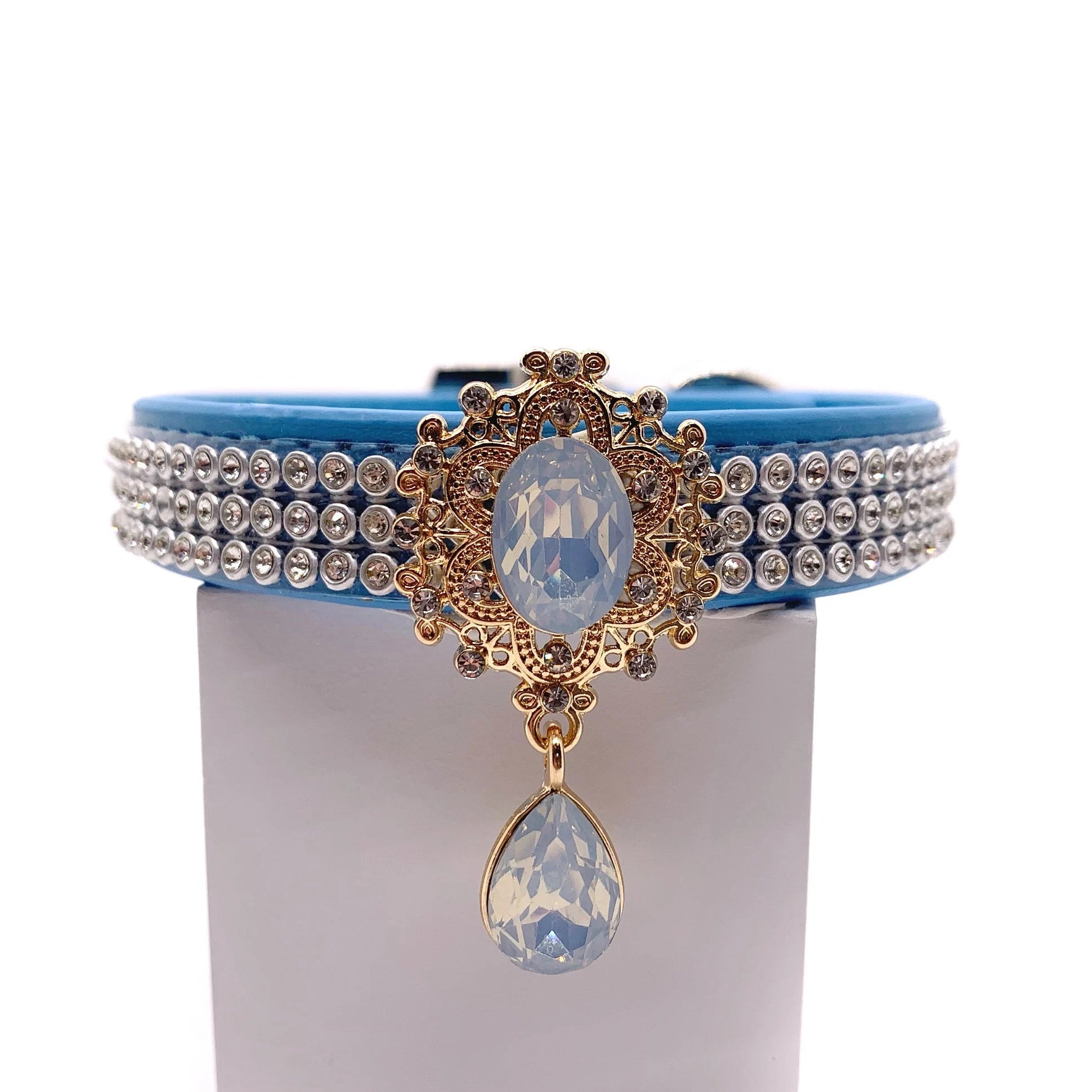 Blue luxury dog collar with triple-row crystal rhinestone band, gold baroque opal oval centerpiece, and dangling iridescent opal teardrop pendant