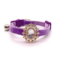 Purple velvet pet collar with a decorative gold and clear gemstone for cats and dogs on a white background
