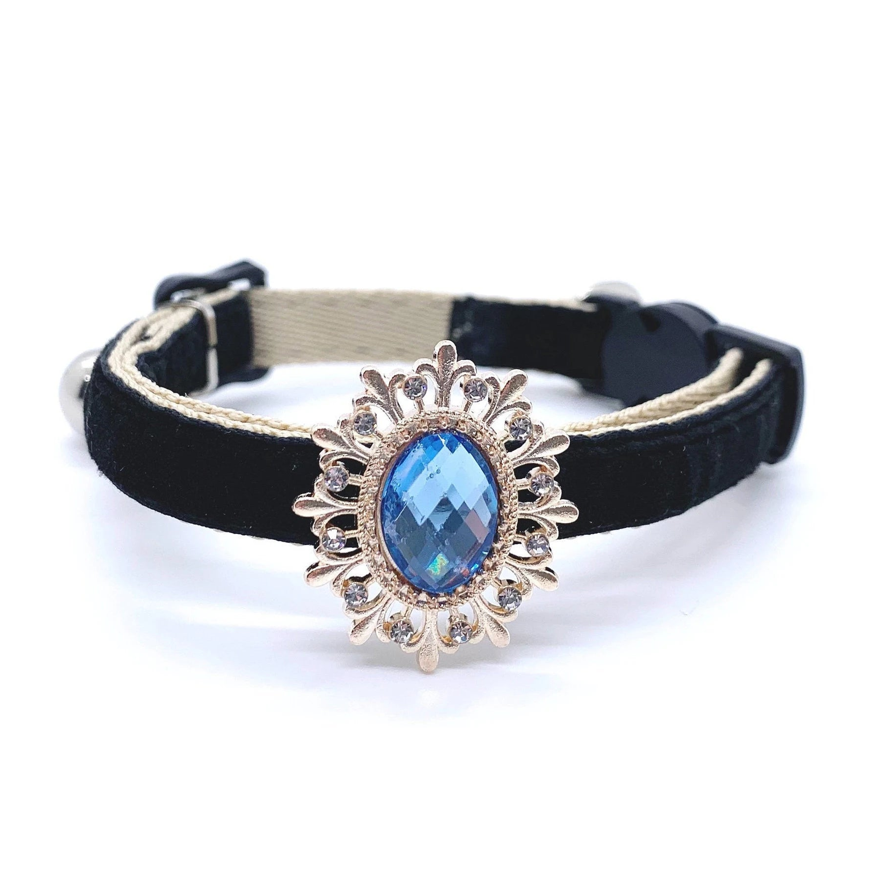 Black pet collar with a decorative gold and blue gemstone on a white background for cats and dogs