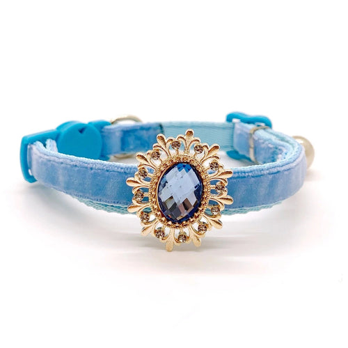 Baby blue velvet cat collar with gold sunflower brooch centerpiece, sapphire blue oval crystal gemstone, and rhinestone petal accents with safety breakaway buckle