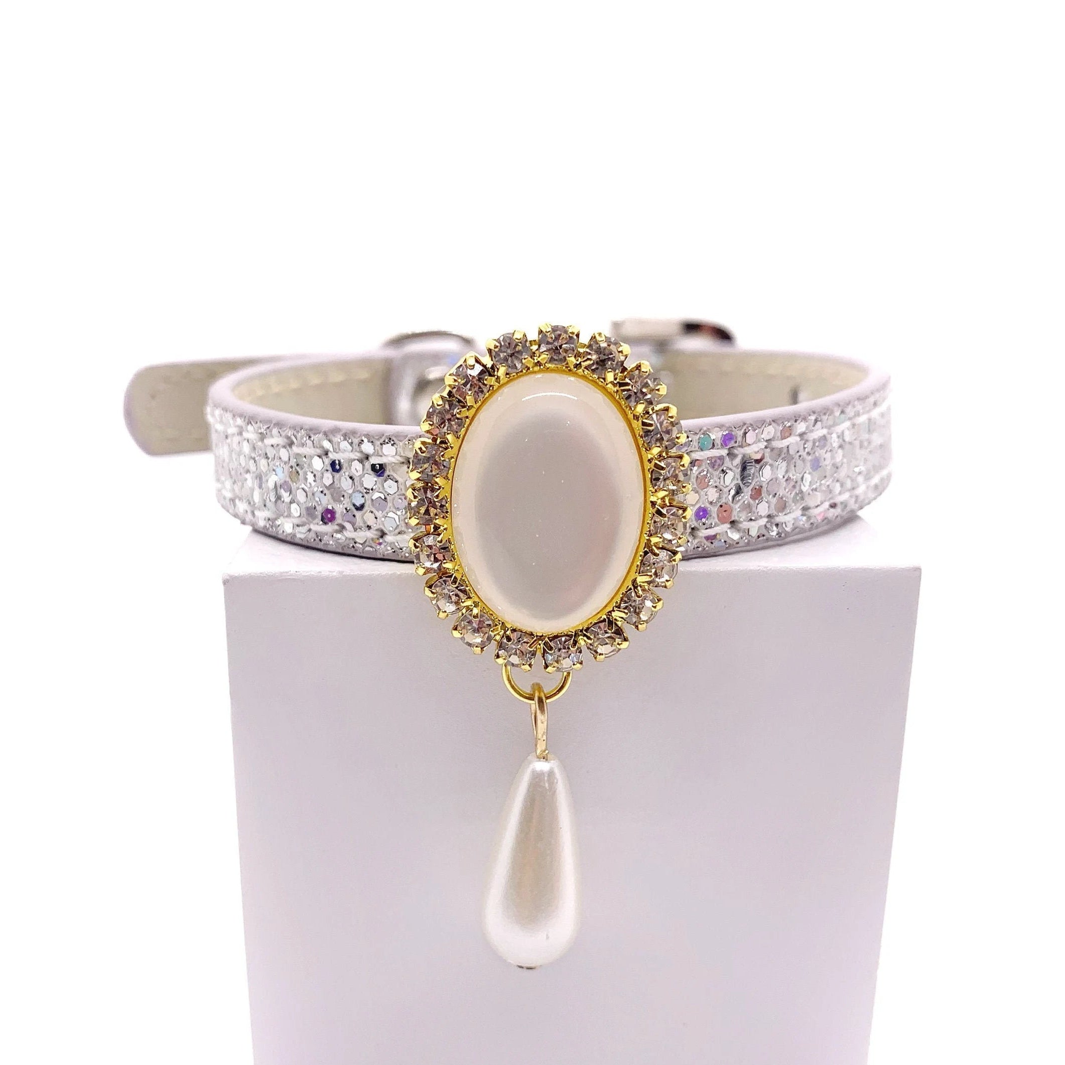 White glitter luxury pet collar with gold oval moonstone centerpiece, crystal halo, and dangling pearl teardrop charm