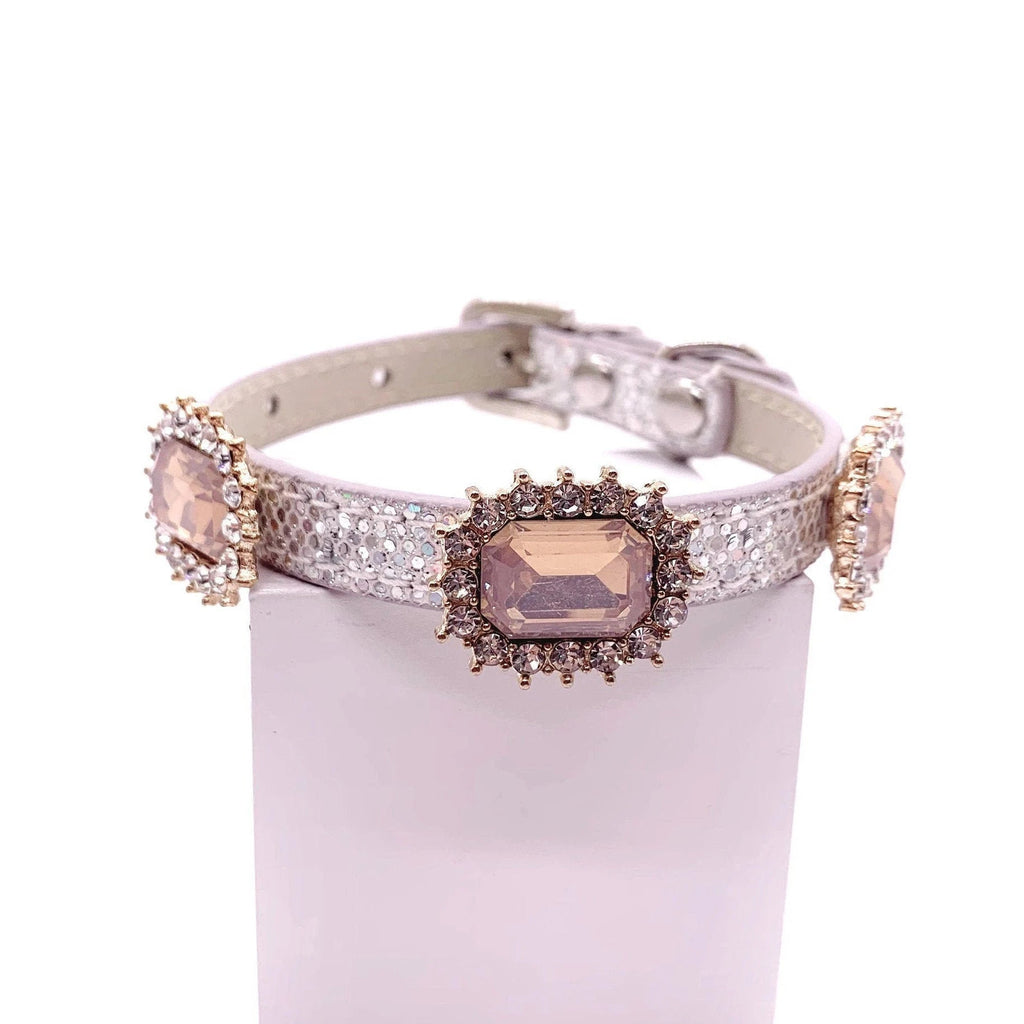 Silver iridescent glitter pet collar with three champagne emerald-cut crystal cabochon charms in gold rhinestone halo settings displayed on stand for cats and dogs