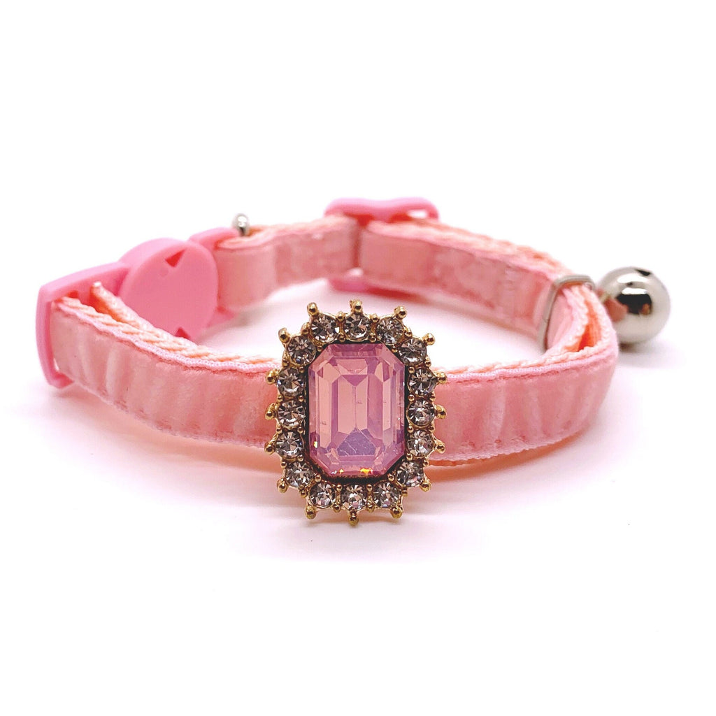 Pink velvet pet collar with pink emerald-cut rhinestone charm, gold halo setting, heart buckle, and silver bell