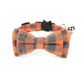 Orange and gray plaid bow tie dog collar with a bell on a white background