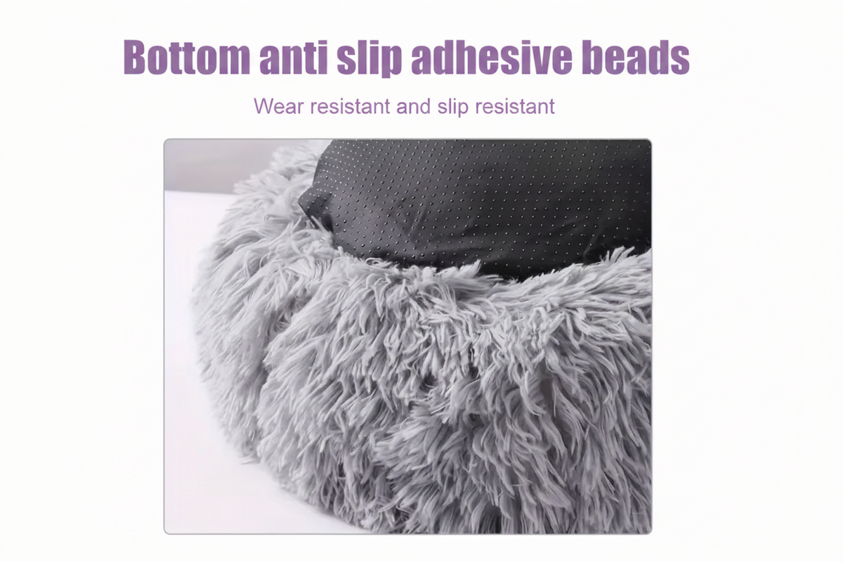 Close-up detail of the non-slip bottom of a light grey shaggy faux fur round donut pet bed, showing the textured black anti-slip adhesive bead base with text reading Bottom anti slip adhesive beads — wear resistant and slip resistant